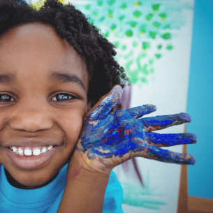 Little boy with painted hands, representing KS1 art ideas
