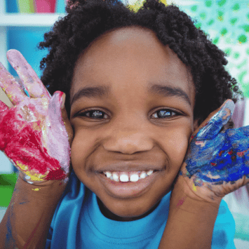Little boy with painted hands, representing KS1 art ideas