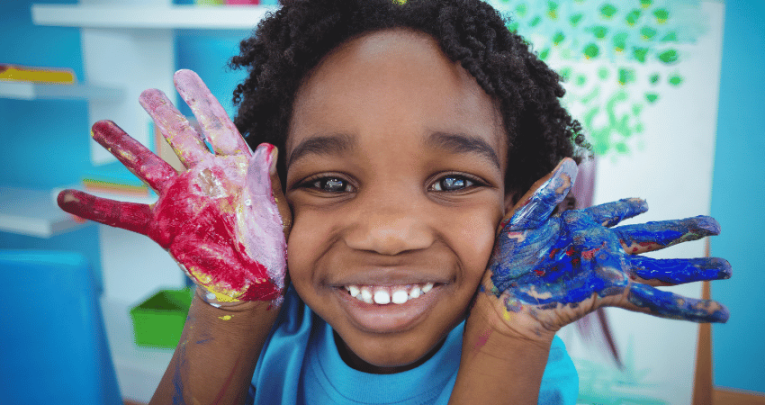 Little boy with painted hands, representing KS1 art ideas