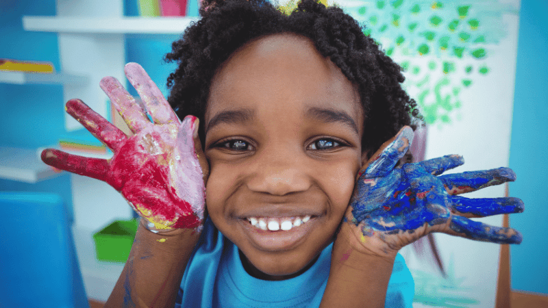 Little boy with painted hands, representing KS1 art ideas