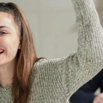 A female student putting her hand up in class