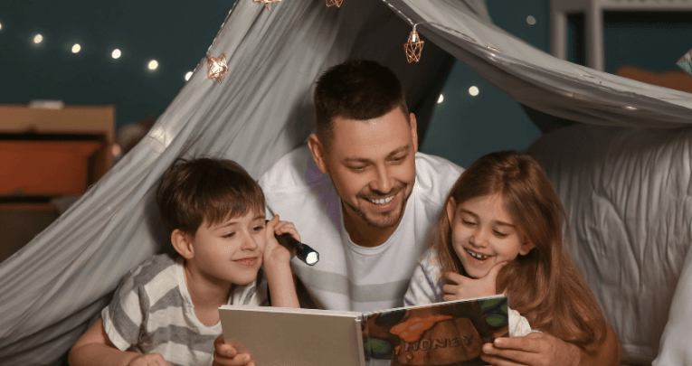 Boy, man and girl reading a book together, representing closing the reading gap