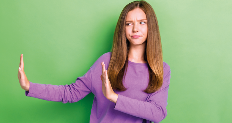 Photo of teenage girl with physical hand movements and facial expression suggestive of refusal, representing alternatives to university