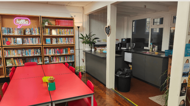 A school room with book shelves and a small kitchen area