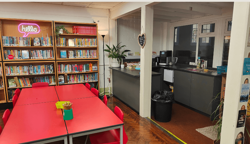 A school room with book shelves and a small kitchen area