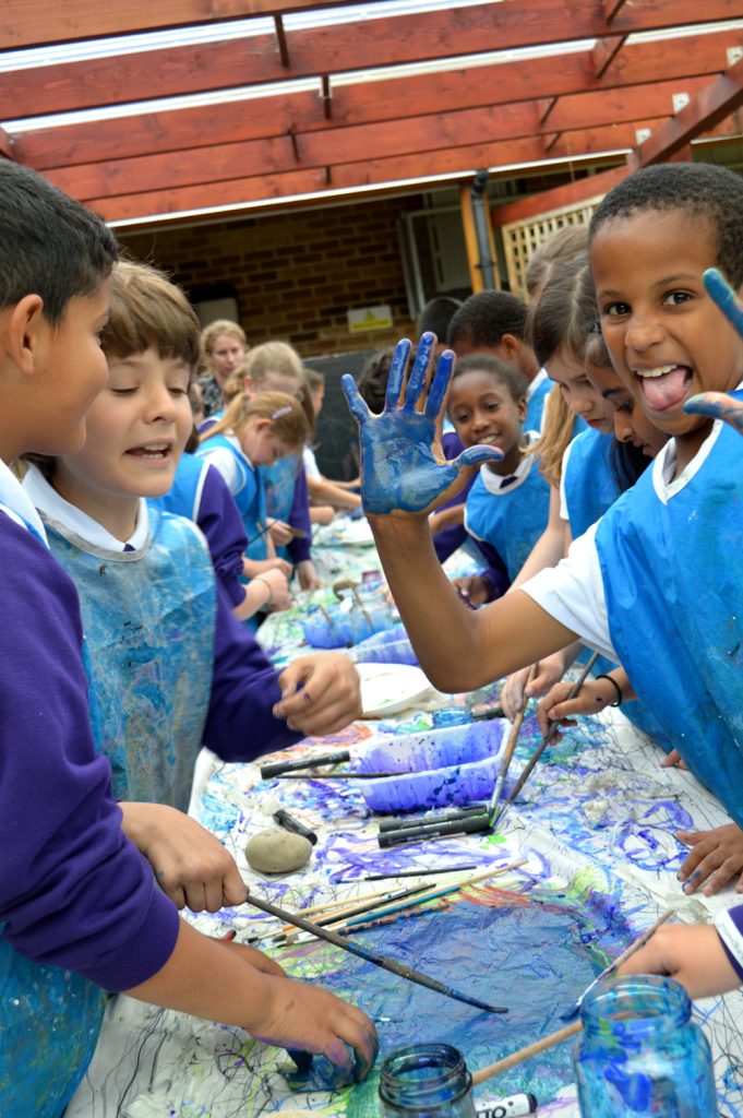Children taking part in messy painting activity for Children's Art Week