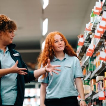 Photo of a young trainee receiving workplace training at a supermarket, representing jobs for people with disabiltieis