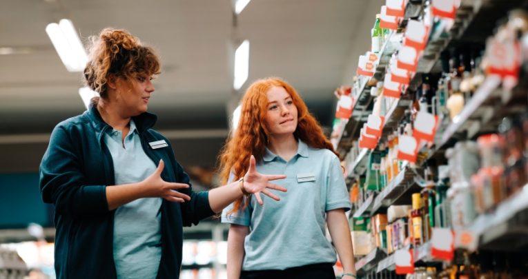 Photo of a young trainee receiving workplace training at a supermarket, representing jobs for people with disabiltieis