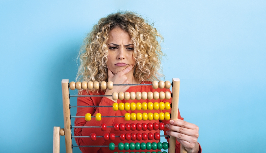 Photo of confused woman holding an abacus, representing maths teachers
