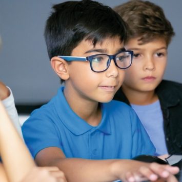 A schoolboy using a laptop in a classroom