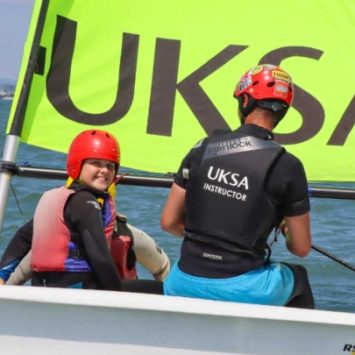 A primary school girl in a sailing boat with a UKSA instructor