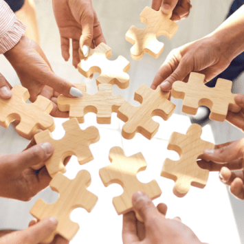 Hands holding jigsaw pieces together, representing collaboration at Badock's Wood Primary