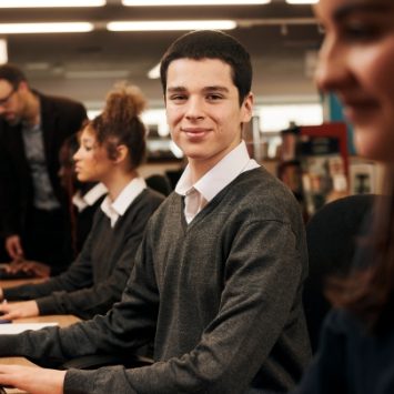 A schoolboy typing on a computer keyboard