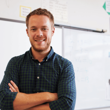 New teacher standing in front of whiteboard, representing Progress 8