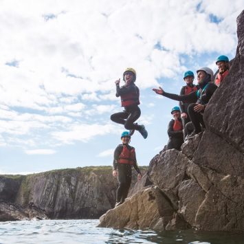A primary school boy jumping into the sea