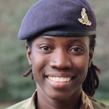 A woman in an army uniform smiling
