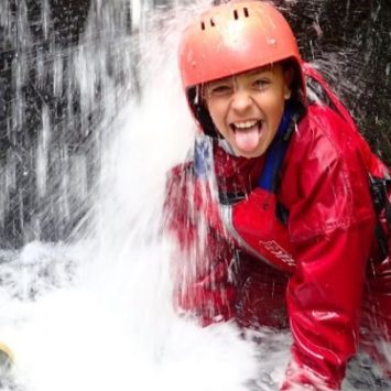 A school girl beneath a waterfall