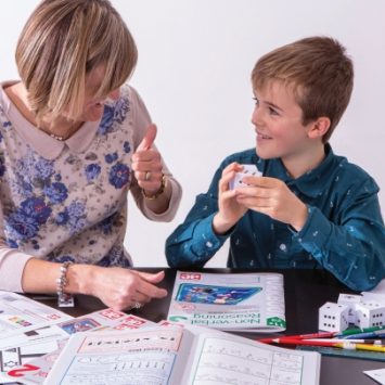 A woman tutoring a school boy