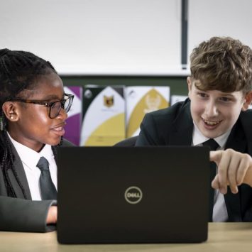 Two secondary school students looking at a laptop