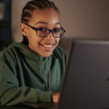 A school girl working at home on a laptop