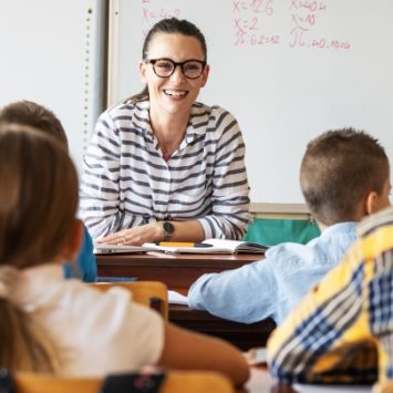 A school teacher smiling at a class of children