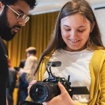 A secondary school girl holding a video camera