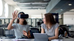 Two secondary school girls using a VR headset
