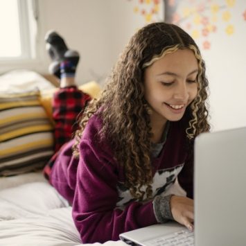 A secondary school girl looking at a laptop