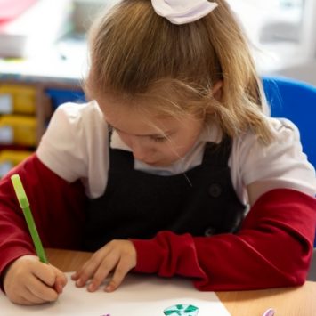 A primary school girl writing at a desk.