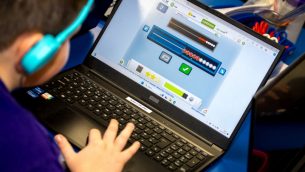 A school child working with a laptop in a classroom