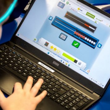 A school child working with a laptop in a classroom