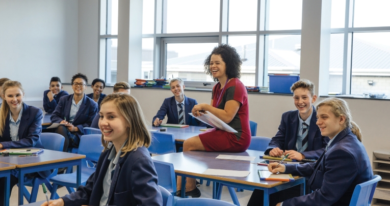 A group of secondary school students with a teacher in a classroom