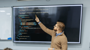 Teacher teaching coding, representing teacher shortage subjects