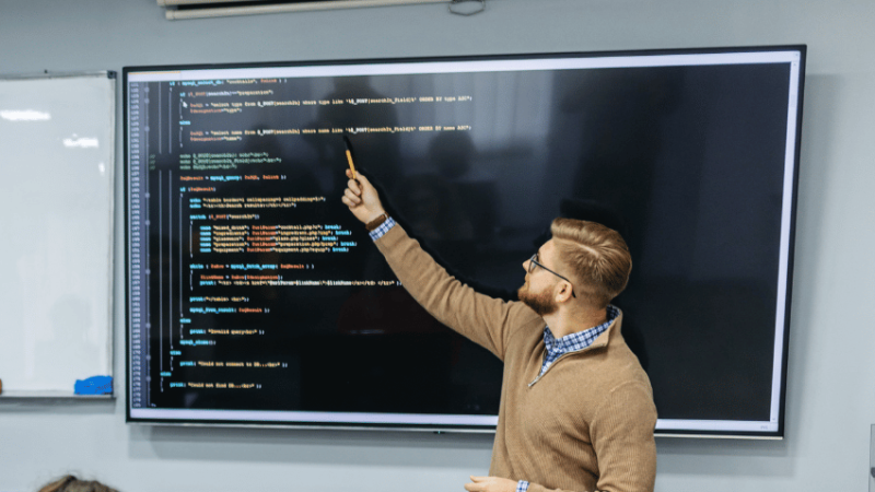 Teacher teaching coding, representing teacher shortage subjects