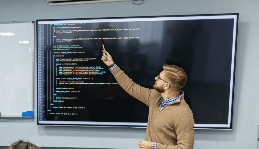 Teacher teaching coding, representing teacher shortage subjects