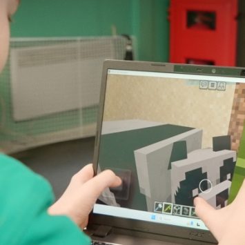 A school boy using a touchscreen on a laptop