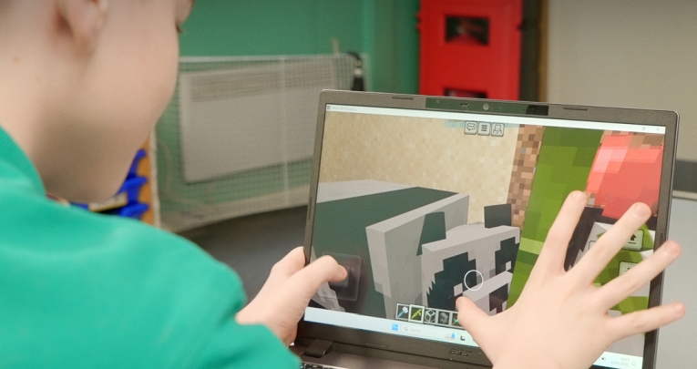 A school boy using a touchscreen on a laptop