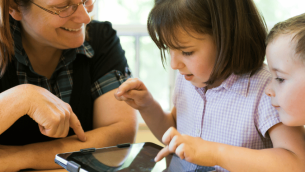 Teacher and pupils using ipad, representing digital and technology standards