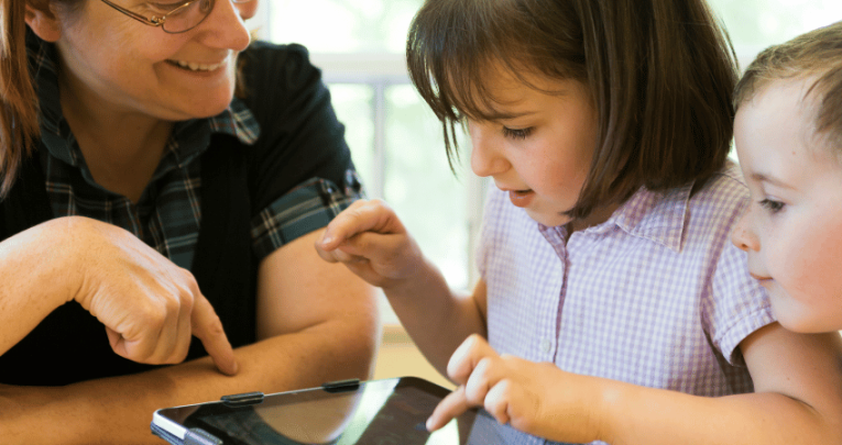 Teacher and pupils using ipad, representing digital and technology standards