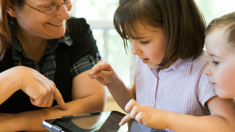 Teacher and pupils using ipad, representing digital and technology standards