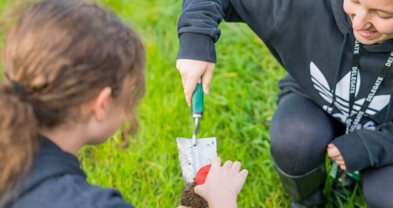An educator and student planting