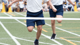 Children running towards finish line at sports day