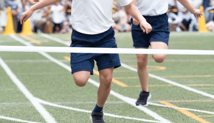 Children running towards finish line at sports day