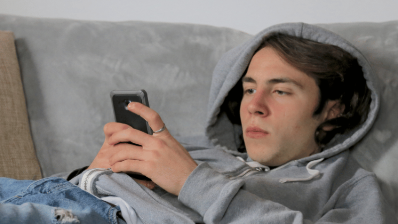 Teenage boy using phone, representing digital resilience