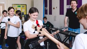 School pupils playing electric guitars during a Rocksteady music session