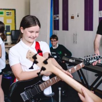 School pupils playing electric guitars during a Rocksteady music session