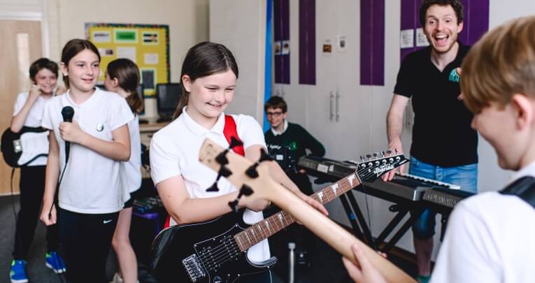 School pupils playing electric guitars during a Rocksteady music session