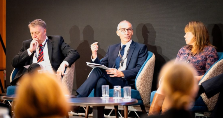 People on stage in a panel at a conference