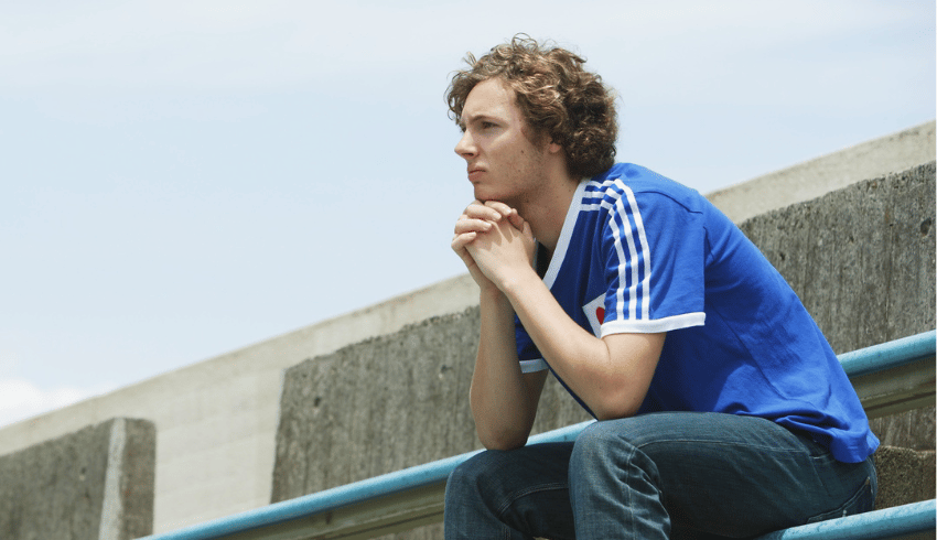 Teenage boy with ADHD sitting outside