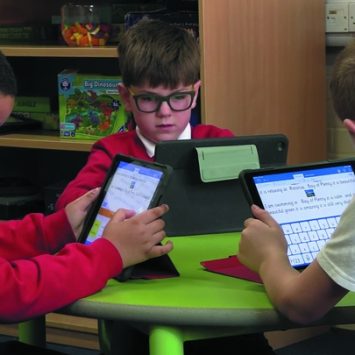 Three primary schoolboys using Clicker at a table